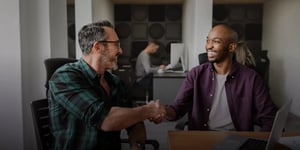 Two men giving a handshake and smiling